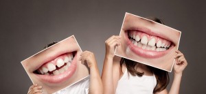 two children holding a picture of a mouth smiling